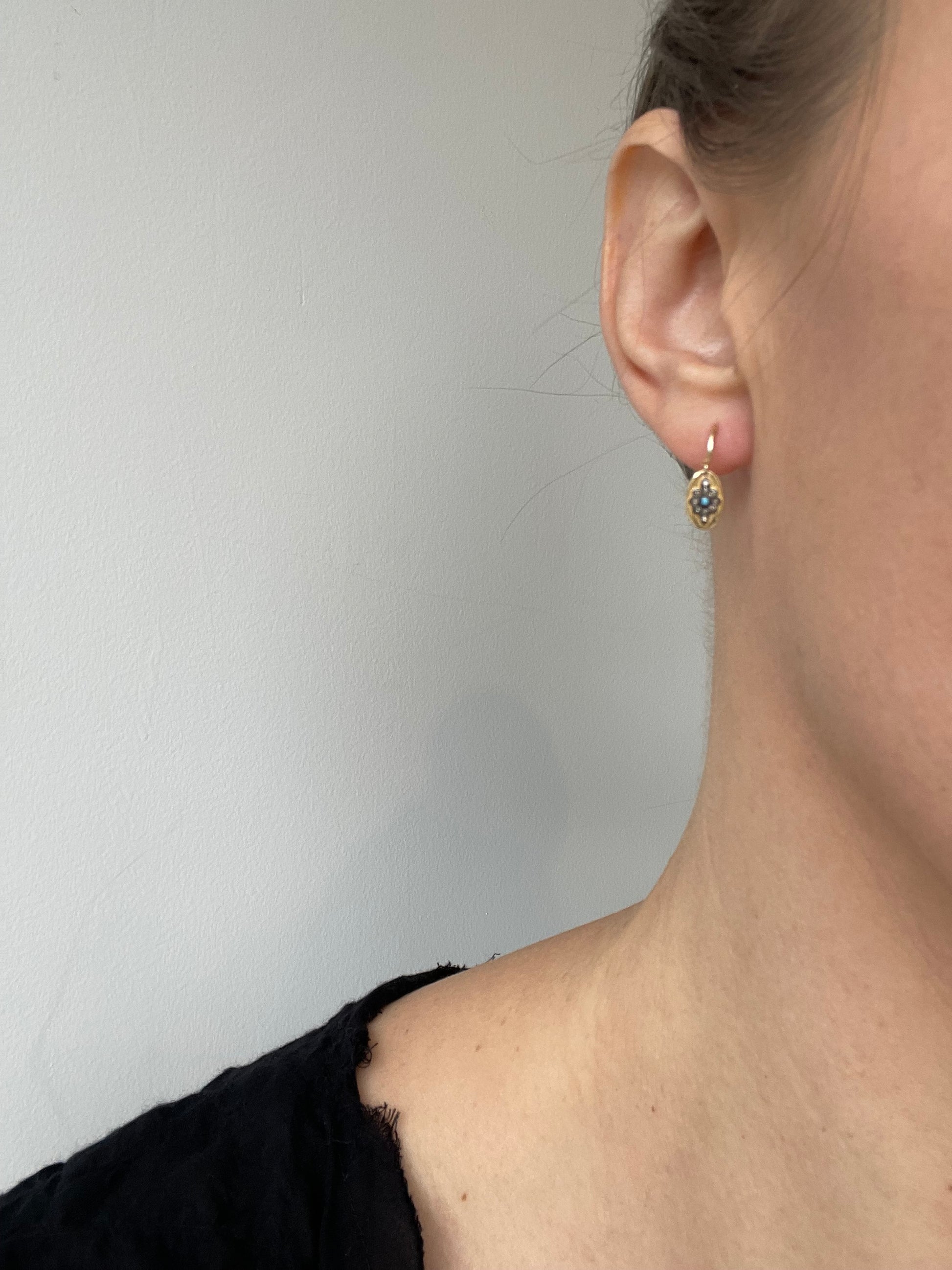 dainty gold dangly earrings with a small turquoise, diamond and oxidized silver