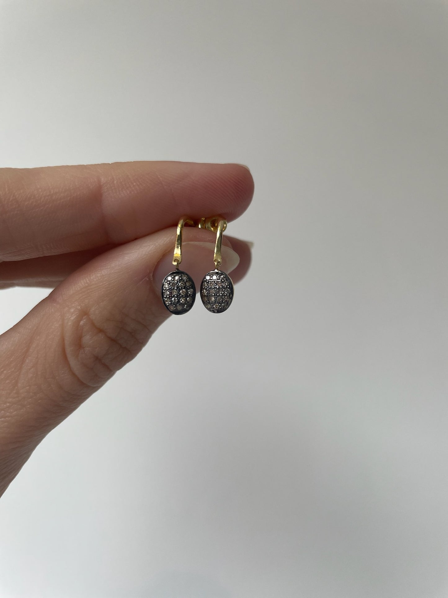 Small dangly gold oval earrings with small diamonds
