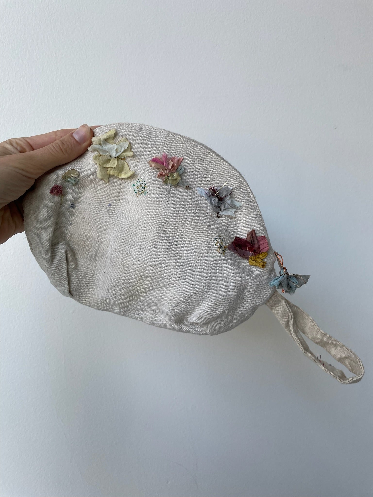 cream linen pouch with hand-embroidered flowers and crushed velvet lining