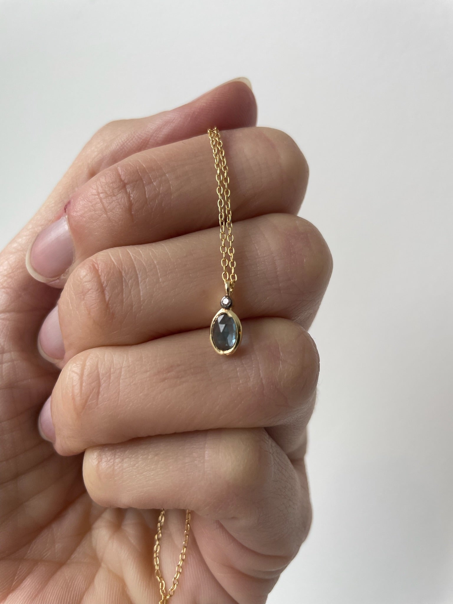 Gold necklace with small blue topaz pendant