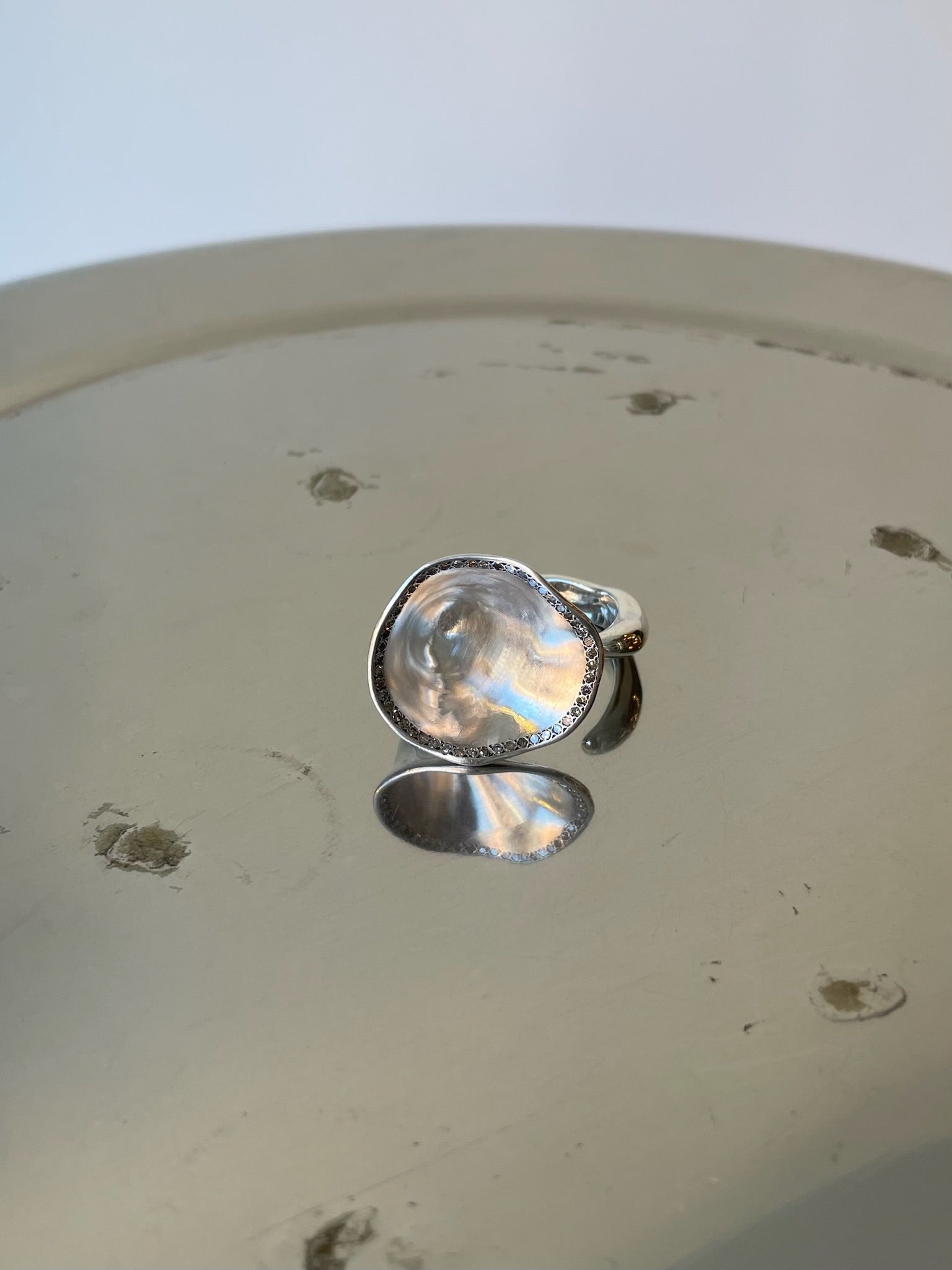 Silver ring with a clear gemstone on a light-colored surface